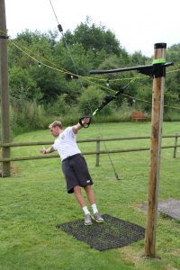 Man Using Fitness Tree On Rubber Grass Mats