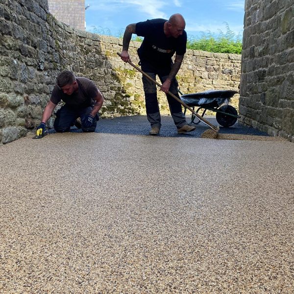 Resin Bound Gravel Being Installed Using A Spazzle and Trowel